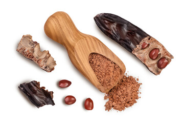 Carob pod and powder in wooden scoop isolated on white background with clipping path. Top view. Flat lay