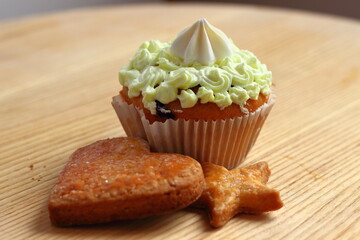 Sweet cupcake with cream and cookies for dessert.