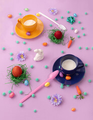, plastic spoons, white bunny and colorfull eggs on violet background.