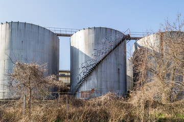 Fototapeta na wymiar Stainless steel metal silos around an abandoned factory - Minaqua in Novi Sad, Serbia.