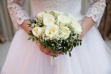 Beautiful wedding bouquet of flowers in the hands of the bride