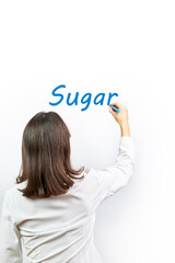 Woman writing the word Sugar on a white background with a blue marker