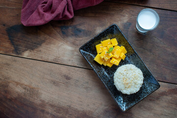 Thai dessert. Sticky rice mango on wood table.