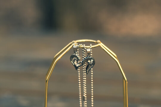 Couple set pendant necklace half of heart shoot outdoors in a sunny day closeup. Selective focus. High quality photo