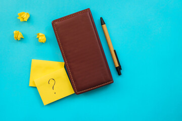 Stickers in the form of a yellow square and a leather notebook lie on a blue background.