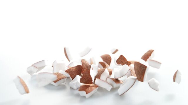 Super Slow Motion Shot of Falling and Breaking Fresh Coconut on White Background at 1000fps.