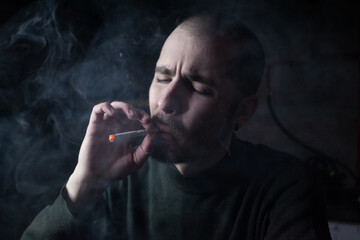 Young man with cigarette in hand feeling lonely and depressed