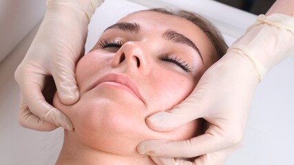 Obraz na płótnie Canvas Beautiful girl has a facial massage in a beauty clinic. concept skin care, spa concept, treatment, facial massage