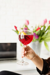 woman hand holding a glass of red wine celebrating spring holidays