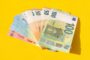 various denominations of euro banknotes isolated on yellow background