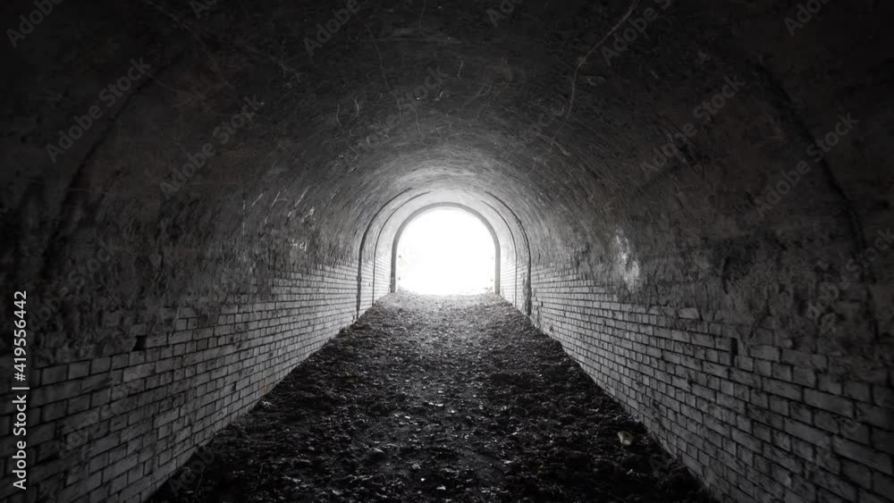 Wall mural exit from the old abandoned brick arch tunnel of the 19th century fortification with light in the en
