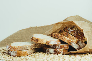 Sourdough bread with crispy crust cut into slices inside a paper bag