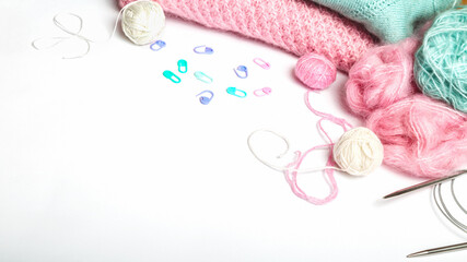 Pink yarn skein, knitting needles, closeup on a white background
