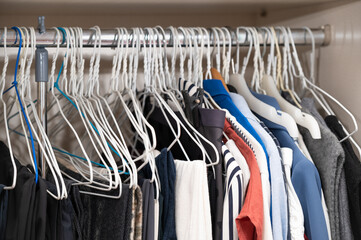 Various clothes hanging on hangers and filling the closet