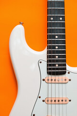 Obraz na płótnie Canvas Detail of White Electric Guitar on a orange background.