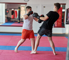 Overweight kickboxer sparring with his partner