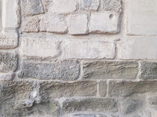 A worn wall of an old architectural structure. In white and gray colors.