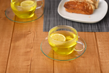 Lemon tea in a glass cup on the wooden table.
