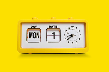 Electronic alarm clock and analog flip calendar. Retro design from 60s 70s home interior. Bright yellow color.