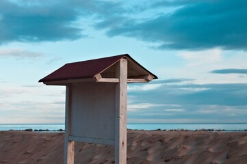 Wooden board sign on the beach in front of a sand dune on the Mediterranean coast (Pesaro, Italy,...