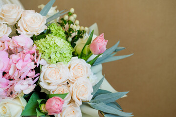 a variety of flowers in a bouquet on a beige background