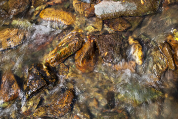 Natural background, the stones at the bottom of the creek. Clean stream.