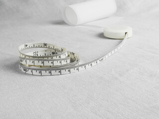 Measuring tape and clothing pattern on gray linen background