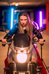 Fototapeta na wymiar Photography with blue and pink neons on a motorcycle. Portrait of a young pretty blond Caucasian woman in a black leather jacket