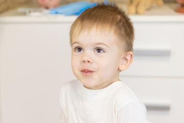 The child drinks water from a glass. Selective focus.