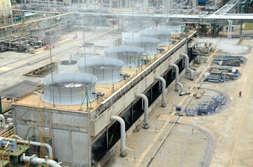 Cooling tower and cooling fan blowing steam on the air in chemical plant, refinery plant, oil and...