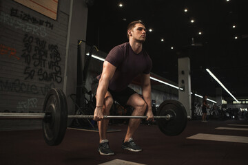 Fototapeta na wymiar Handsome young male athlete doing deadlift exercise at functional training gym