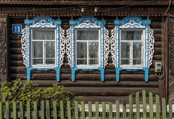 Fototapeta na wymiar Old Russian Log Cabin with Green Fence