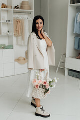 stylish brunette girl in a jacket with a bag posing in the studio