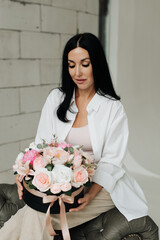 brunette woman sitting on the sofa with a bouquet of flowers