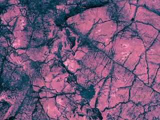 Rough textured dark pink matte abstract stone with cracks background. Relief wall