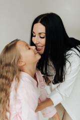 beautiful young mom hugs daughter with long hair