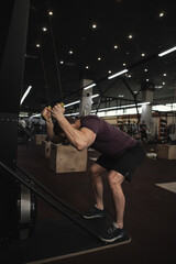 Male athlete exercising on ski machine at gym