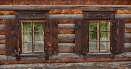 Fototapeta na wymiar Russian Wooden Log Cabin with Wooden Shutters