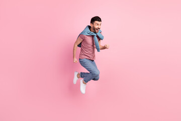 Full size photo of happy excited crazy smiling positive handsome man running fast in air isolated on pink color background