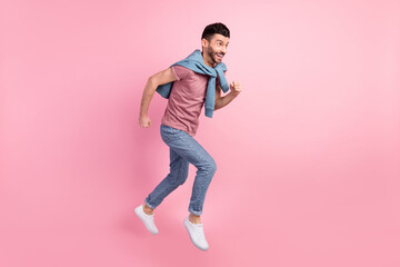 Fototapeta na wymiar Full size profile side photo of happy excited smiling good mood man running fast in air isolated on pink color background