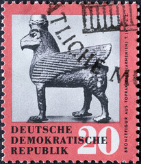 GERMANY, DDR - CIRCA 1959 : a postage stamp from Germany, GDR showing a bronze figure: horse with beak and wing from Toprak-Kale, Armenia (700 BC). antique art treasure