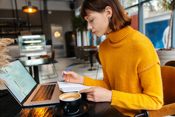 Attractive girl student studying online from her laptop