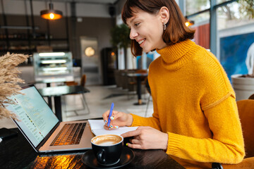 Attractive girl student studying online from her laptop