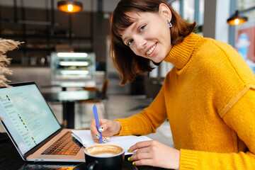 Attractive girl student studying online from her laptop