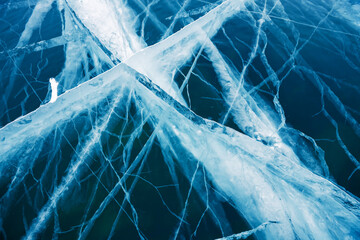Transparent cracked blue ice on Baikal lake in winter. Beautiful winter nature background. Baikal,...
