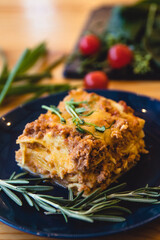 Piece of tasty hot lasagna with red wine. Selective focus