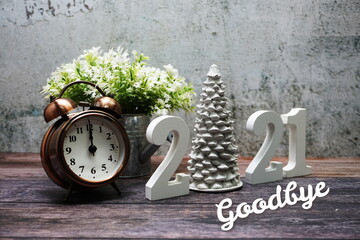 Goodbye 2021 calligraphy alphabet letter and Christmas tree Holiday Decoration on wooden background