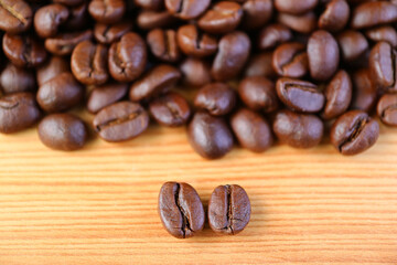 Closeup of Arabica VS Robusta Roasted Coffee Beans with Blurry Coffee Beans Pile in the Backdrop