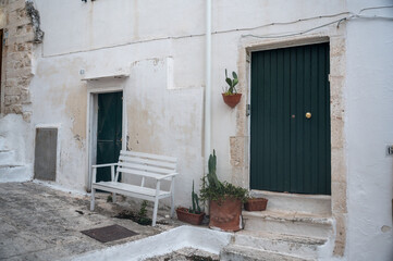 Fototapeta na wymiar facade with doors and bench in Ostunis oldtown, Puglia