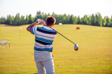 A golfer in the finishing position after hitting a tee shot
